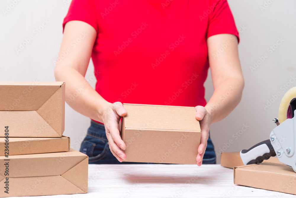 Woman packing cardboard boxes , picking and puttind products Woman packing cardboard boxes , picking and puttind products