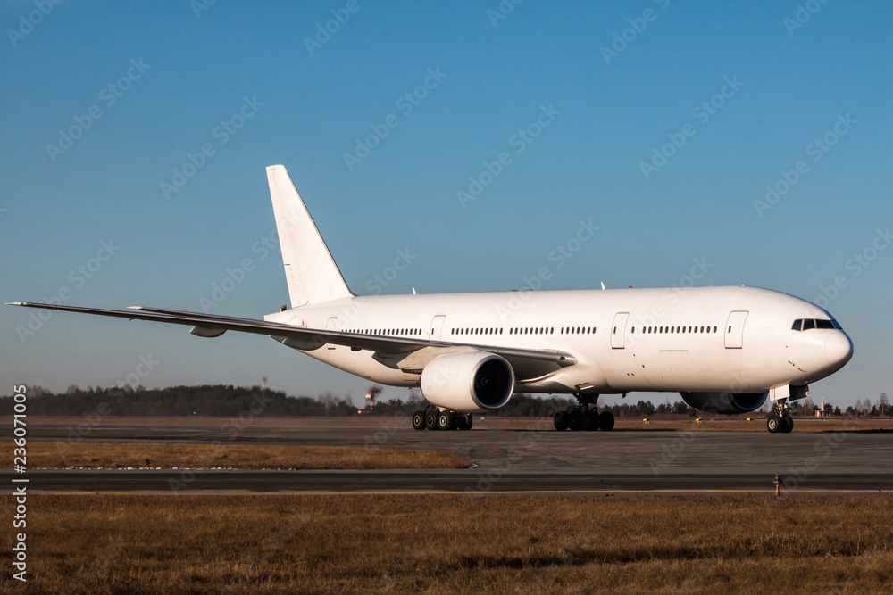 White wide body passenger aircraft taxiing on the main taxiway White wide body passenger aircraft taxiing on the main taxiway
