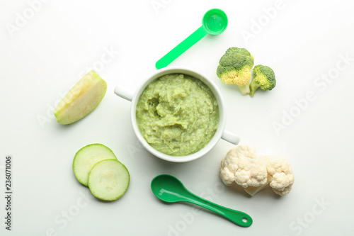 Flat lay composition with healthy baby food in casserole and ingredients on white background