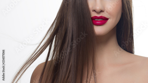 Close-up of woman's lips with fashion bright pink make-up. Beautiful female mouth, full lips with perfect makeup. Part of female face. Choice lipstick. Pink wavy hair of a Baby doll