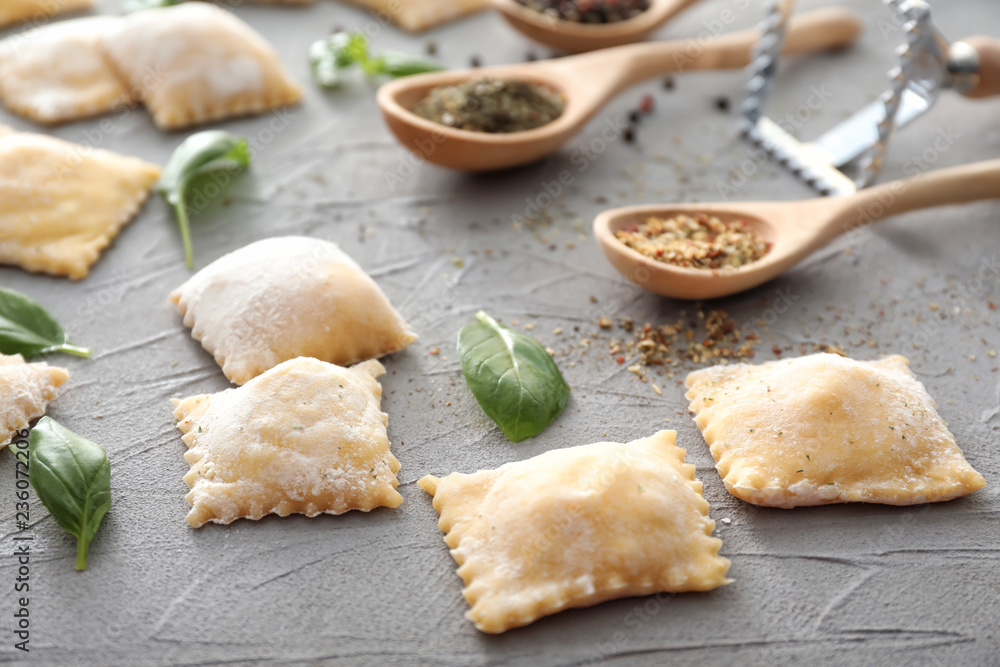 Uncooked ravioli with spices on grey textured background Uncooked ravioli with spices on grey textured background