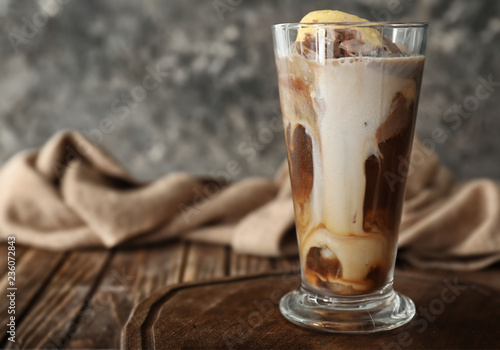 Glass of cold coffee with ice cream on wooden table photo