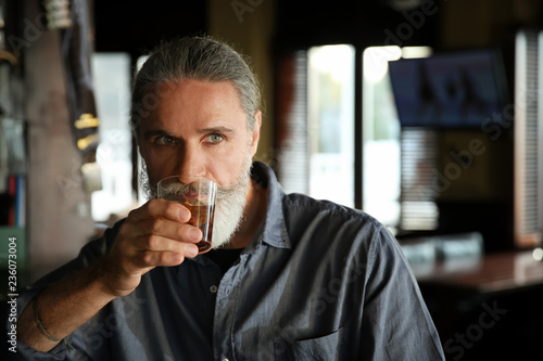 Senior man drinking whiskey...