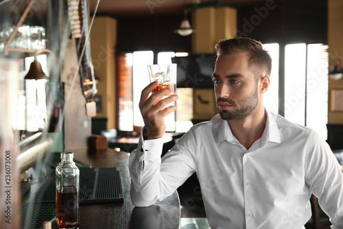 Young man drinking whiskey ...