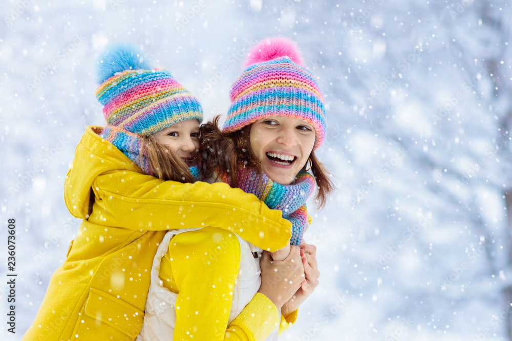 Mother and child in knitted winter hats in snow. Mother and child in knitted winter hats in snow.