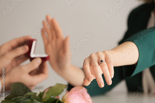 Young woman rejecting marriage proposal because she is already engaged