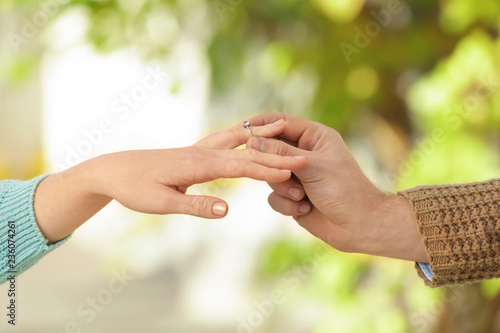 Young man putting engagement ring on fiancee's finger © Pixel-Shot