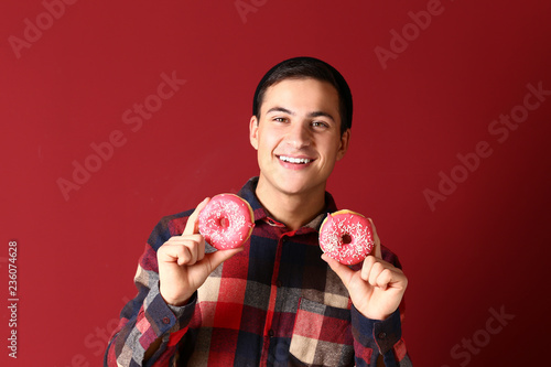 Young man with tasty donuts...