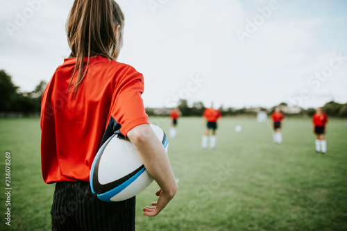 Valokuva Female rugby player holding the ball in her arms