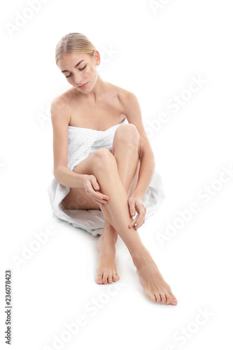Beautiful young woman with shaved legs on white background