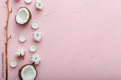 Beautiful composition with burning candles, coconut and cotton flowers on color background