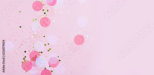 Pink confetti and stars and sparkles on pink background. Top view, flat lay. Copyspace for text. Bright and festive holiday background. For Christmas, New year, Mother's day. © paninastock