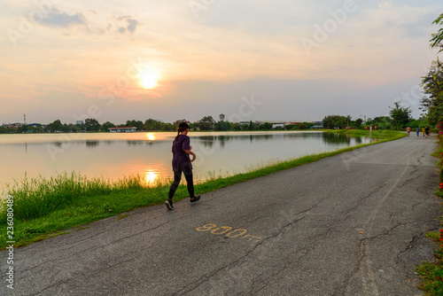 undefined people running at the lake in sunset time
