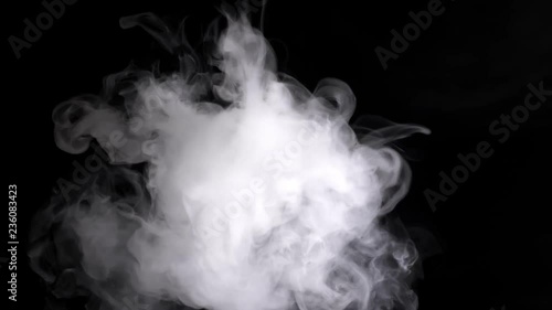 Thick beautiful smoke envelops the black space and slowly moves on a black background attracting the eye and moving