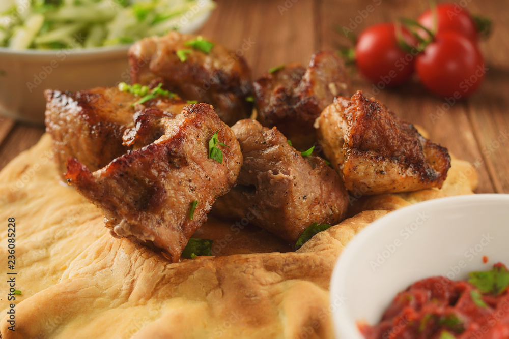 Juicy, hot grilled pork on pita with lettuce, spices, onions and peppers Juicy, hot grilled pork on pita with lettuce, spices, onions and peppers