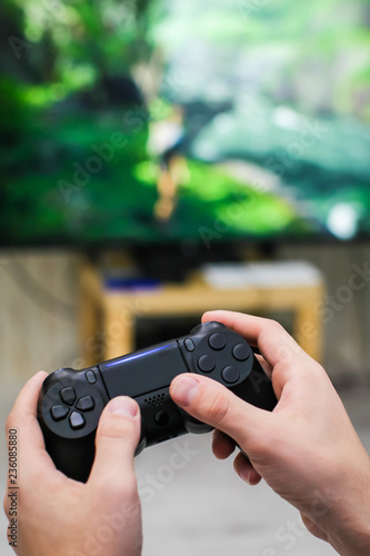 Close up view of man's hands with controller for playing video game