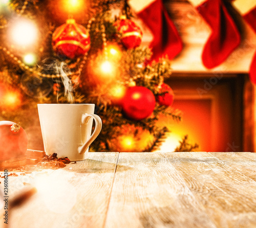 Christmas mug on wooden table and fireplace  © magdal3na