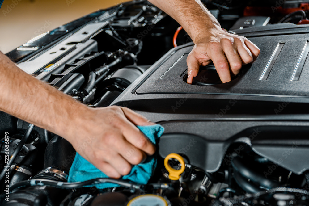 cropped shot of auto mechanic with rag checking automobile cropped shot of auto mechanic with rag checking automobile