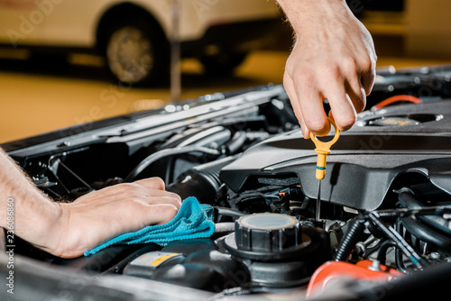 cropped shot of auto mechanic with rag checking automobile © LIGHTFIELD STUDIOS