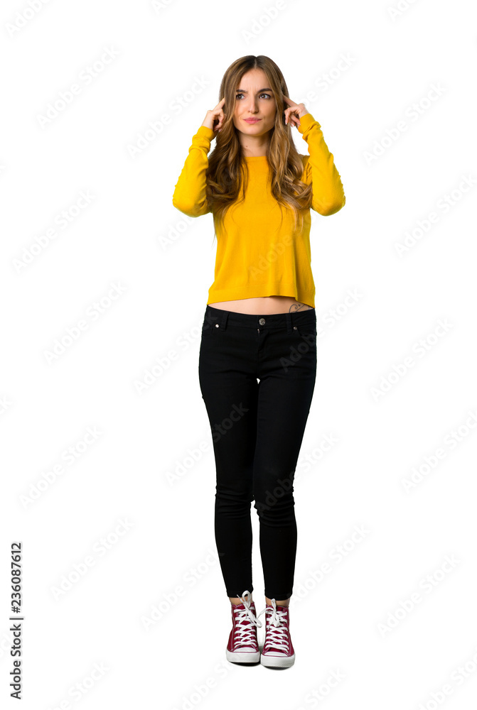 A full-length shot of a young girl with yellow sweater having doubts and thinking on isolated white background A full-length shot of a young girl with yellow sweater having doubts and thinking on isolated white background