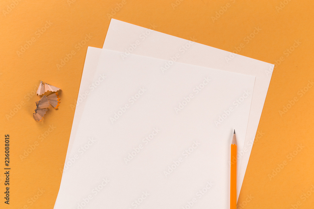 white paper sheets with pencil on orange desk white paper sheets with pencil on orange desk