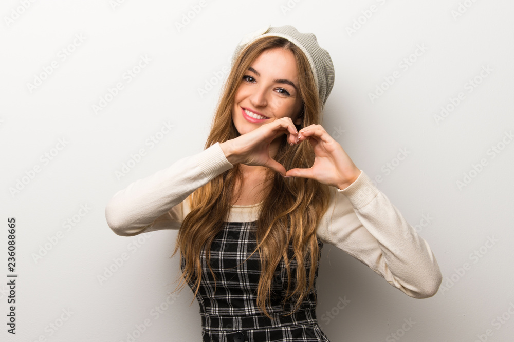 Fashionably woman wearing hat making heart symbol by hands Fashionably woman wearing hat making heart symbol by hands