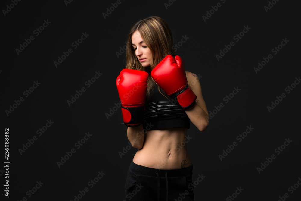 Sport woman with boxing gloves on dark background