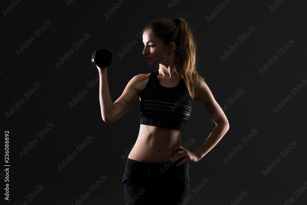 Sport woman making weightlifting on dark background Sport woman making weightlifting on dark background