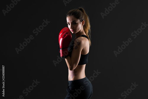 Sport woman with boxing gloves on dark background © luismolinero