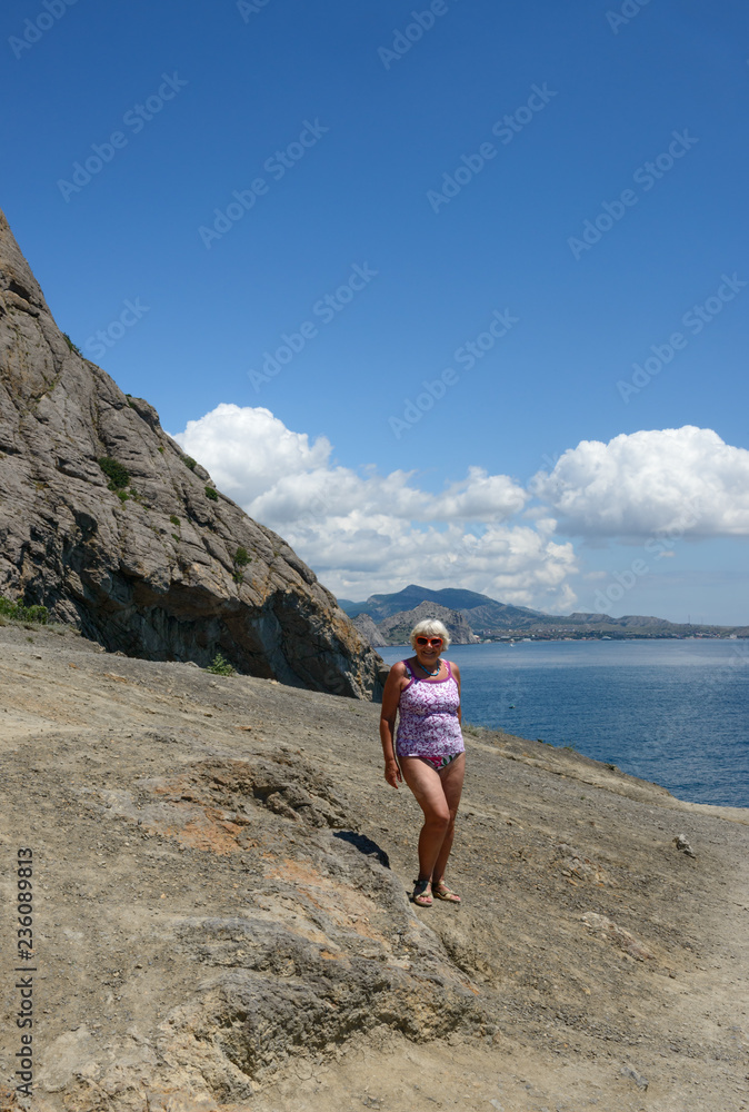Senior woman is on Golitsyn Trail, Novy Svet, Crimea, Russia. Senior woman is on Golitsyn Trail, Novy Svet, Crimea, Russia.