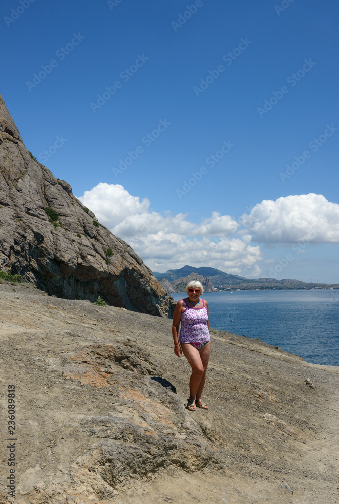 Senior woman is on Golitsyn Trail, Novy Svet, Crimea, Russia.