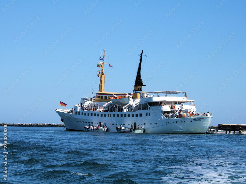 Das Seebäderschiff die MS Atlantis vor der Hochsee Insel Helgoland auf Reede. Das Schiff Atlantis liegt zwischen der Insel Helgoland und der Dühne vor Anker