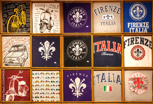 Many colorful souvenir t-shirts for tourists with popular symbols of Tuscany
