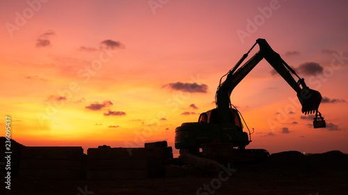 Wallpaper Mural The silhouette excavator is digging ground and lifting a large mortar, with engineering and construction workers to help with colorful sunset . Torontodigital.ca