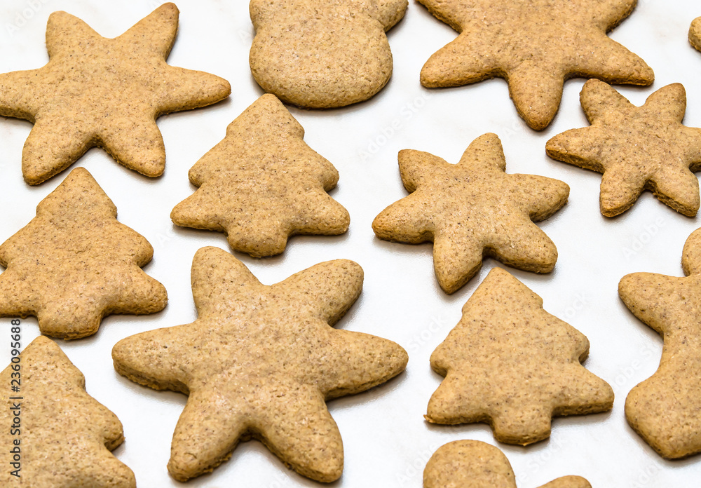 Home-baked gingerbread on a kitchen surface with baking paper - Christmas concept with home-baked cookies in the kitchen Home-baked gingerbread on a kitchen surface with baking paper - Christmas concept with home-baked cookies in the kitchen