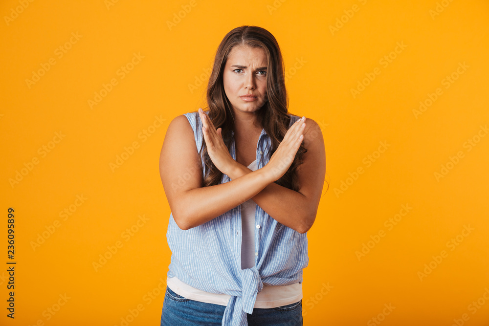 Upset young woman standing isolated over yellow Upset young woman standing isolated over yellow