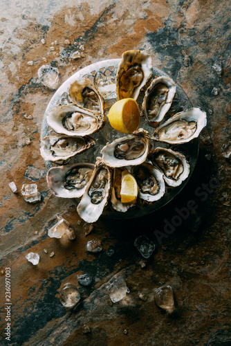 top view of oysters, ice and lemon on grungy tabletop