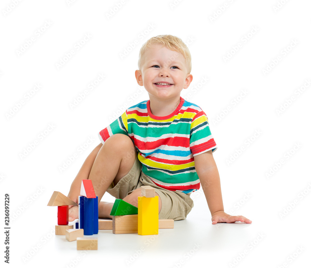 Handsome kid boy smiles and plays with colrful blocks Handsome kid boy smiles and plays with colrful blocks