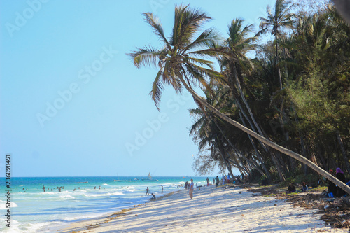 Mombasa, Kenya - December 21, 2015: Diani Beach Indian Ocean Beach - palm trees, turquoise water and white sand photo