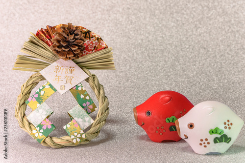 Japanese New Year's Cards with golden ideograms Gingashinnen which means Happy New Year with cute Zodiac animals figurines of two boars, origami range and straw ornament on glitter silver background. photo