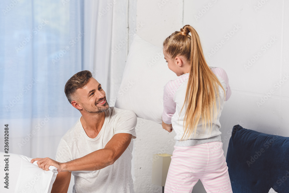 Father and daughter having pillow fight in bedroom Father and daughter having pillow fight in bedroom
