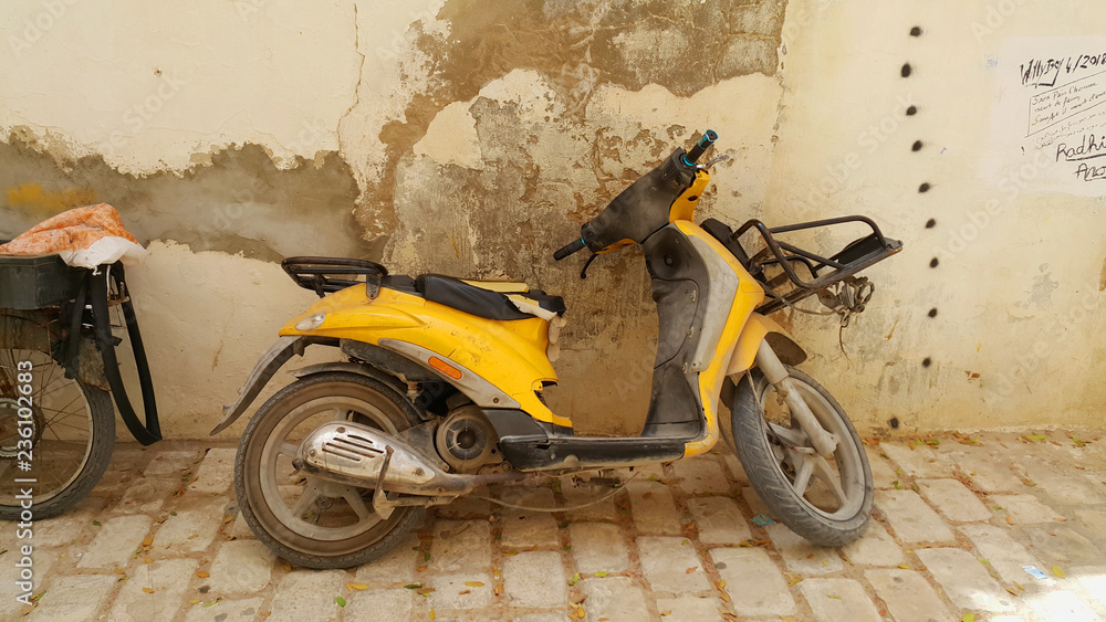 Vintage yellow motorcycle in old town located in Djerba Island in Tunisia.