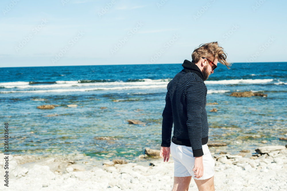 Young man walking on a beach in Gotland, Sweden Young man walking on a beach in Gotland, Sweden