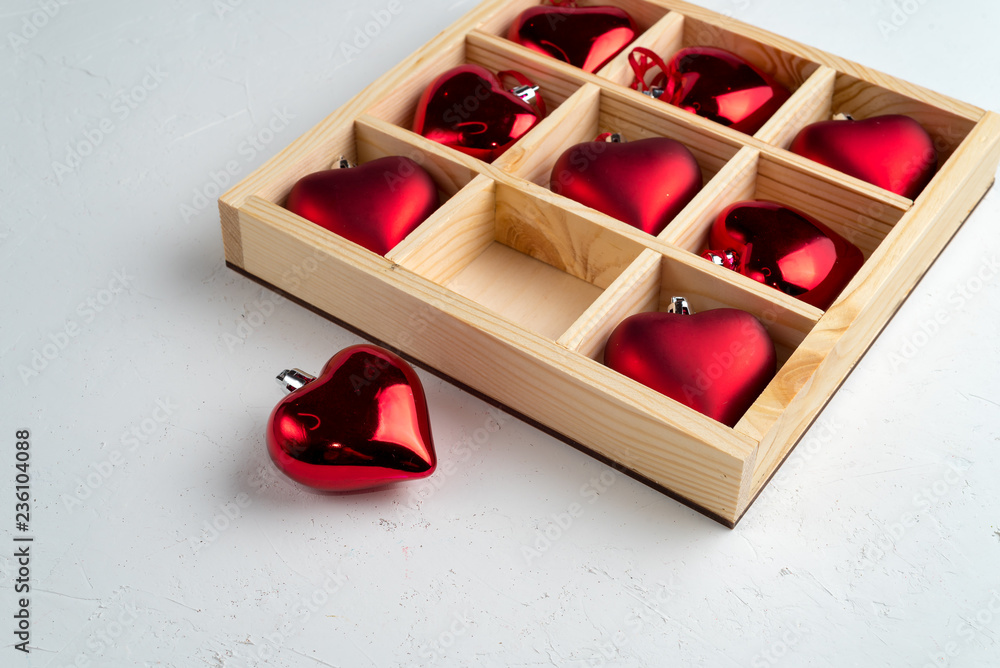Wooden box filled with heart shaped christmas ball, isolated on white Wooden box filled with heart shaped christmas ball, isolated on white
