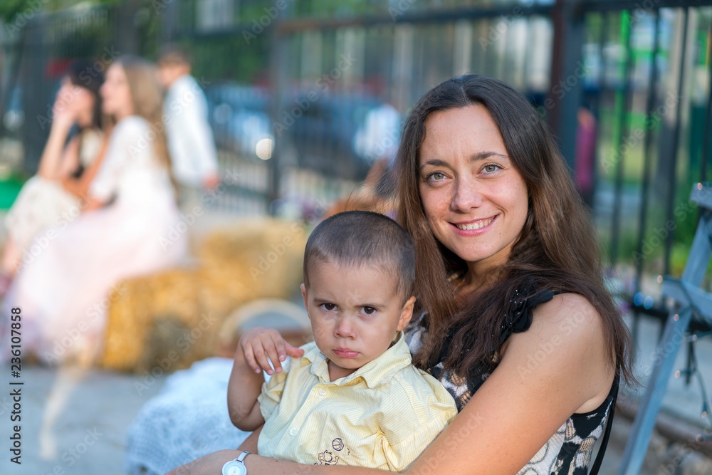 Obraz premium Mom holds a child in her arms. A happy family. Young mother holding her baby in her arms and stroked my mother's child litso. Portret mother and little son.