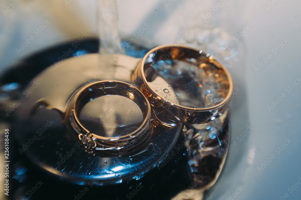 beautiful golden wedding rings on sparkling background