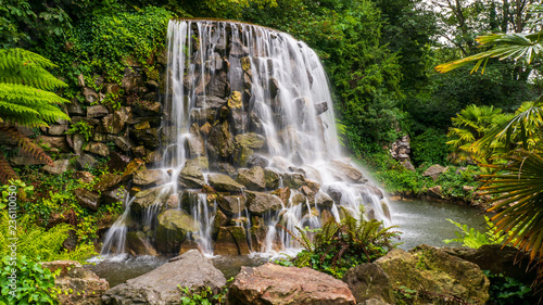 Long exposure of one of the Dublin's hidden gems, a lovely waterfall in Iveagh Gardens, in the city center, side view. Calm landscape in Ireland.