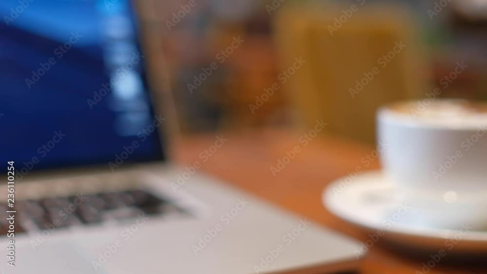 Blurry, defocus, out focus of a cup of cappuccino coffee with laptop on table. Royalty high quality free stock image of capuccino coffee with laptop for working in a coffee shop. Blur background Blurry, defocus, out focus of a cup of cappuccino coffee with laptop on table. Royalty high quality free stock image of capuccino coffee with laptop for working in a coffee shop. Blur background