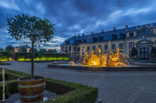 Germany, Lower Saxony, Hanover, Herrenhaeuser Gaerten, Neptune Fountain at Gallery, Orangenparterre in the evening photo