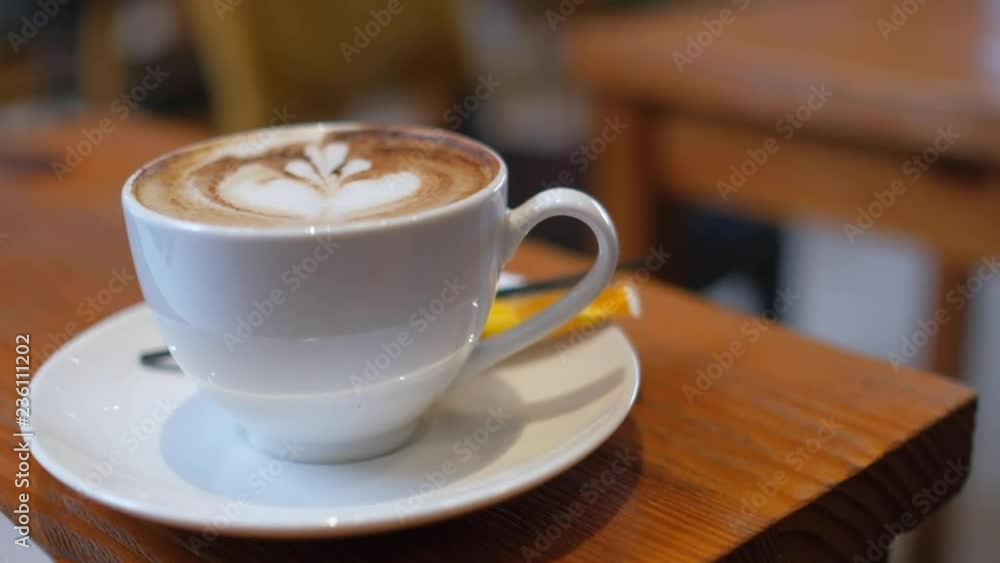 A white cup of cappuccino coffee on table with copy space for texture advertising. Royalty high-quality free stock footage of capuccino coffee with blank cup and copyspace for texture in a coffee shop A white cup of cappuccino coffee on table with copy space for texture advertising. Royalty high-quality free stock footage of capuccino coffee with blank cup and copyspace for texture in a coffee shop